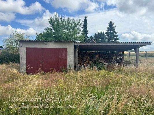 Garage und überdachter Holzlagerplatz am östlich