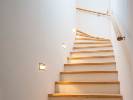 Treppe ins Obergeschoss mit moderner, indirekter Beleuchtung