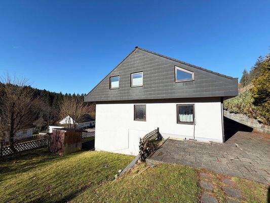 Außenansicht: Blick auf das Haus mit der Dachgeschosswohnung in ruhiger Lage im Grünen