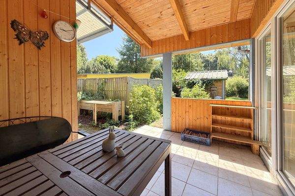 überdachte Terrasse mit Blick in den Garten