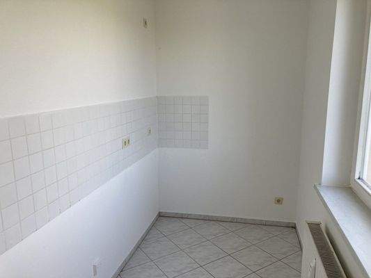 geflieste Küche mit Fenster und Fliesenspiegel