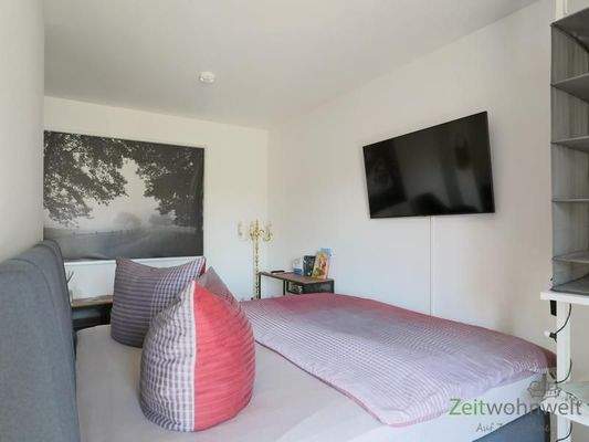 Bett und TV hinter dem Raumteiler