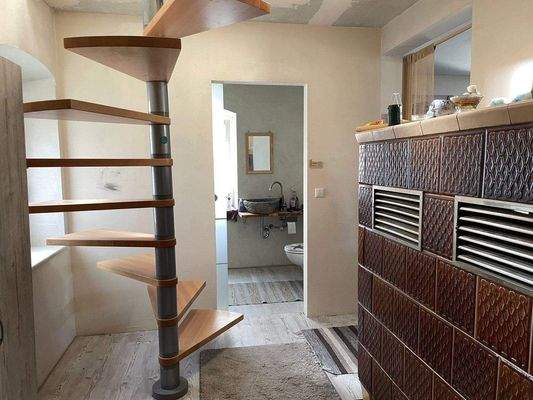 Flur mit Kachelofen und Treppe ins OG