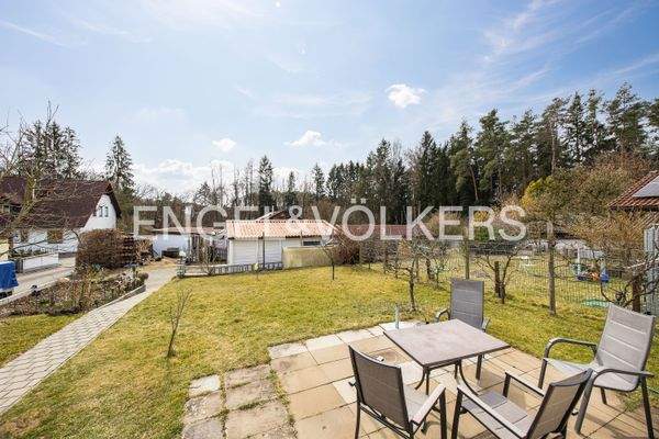 Südlicher kindgerechter und weitläufiger Garten mit Blick auf die Zufahrt und auf die Doppelgarage mit Schuppen zur Holzlagerung