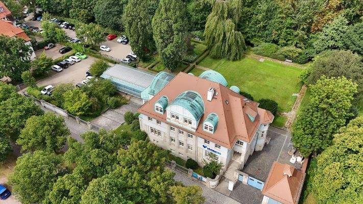 Luftbild mit Blick auf das Gesamtgebäude sowie der grundstückseigenen Parkanlage