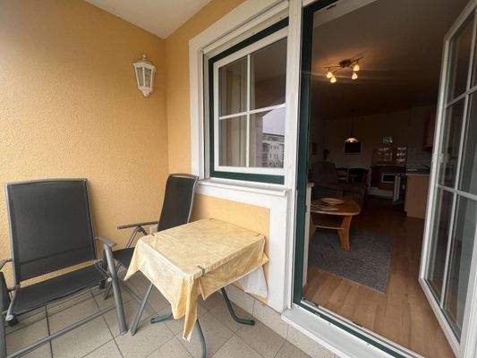 Gemütlicher Balkon mit Blick ins Wohnzimmer und praktischer Sitzgelegenheit