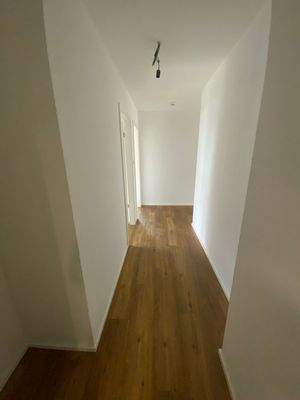 Flur im Eingangsbereich mit weißen Wänden und Vinylboden in Holzoptik.JPG