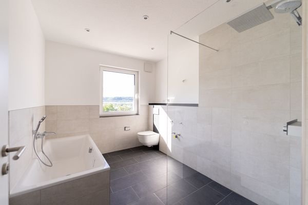 Badezimmer mit Badewanne und bodentiefer Dusche
