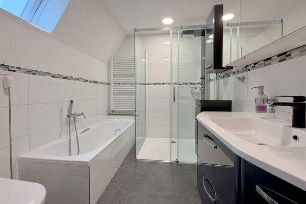 Modernes Badezimmer mit Badewanne, Dusche und WC