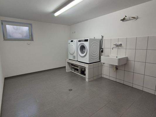 Geräumige Waschküche mit Podest und Wäscheschacht