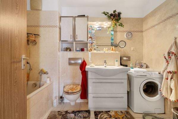Innenliegendes Badezimmer mit Wanne und Waschmaschinenanschluss