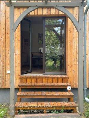 Gartenseitiger, überdachter Eingang in die Wohnku