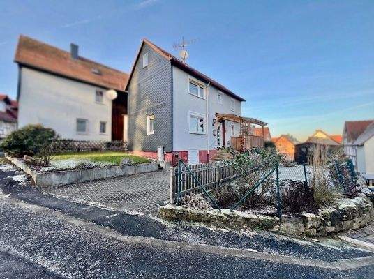 die behagliche Immobilie mit offenem Vorgarten, Stellplatz und eingefriedetem Garten