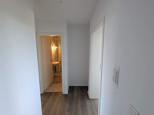 Blick von Flur zu Garderobe und Bad