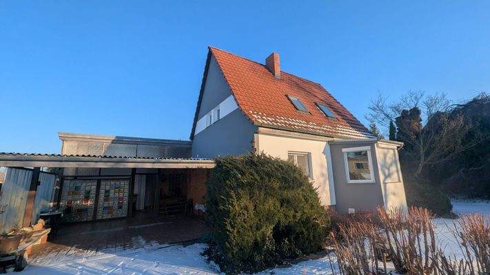 Wohnhausansicht mit überdachtem Eingangsbereich des Anbaus