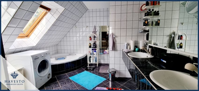 Blick in das helle Badezimmer mit Eckbadewanne und Dusche