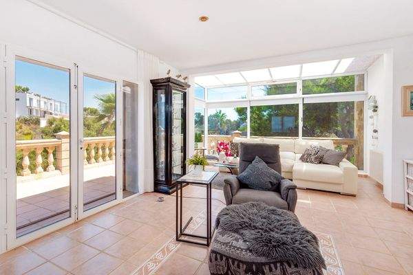 Helles Wohnzimmer mit Kamin und Zugang zur sonnigen Terrasse mit Weitblick