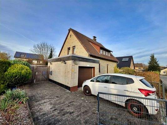 Blick auf die befestigte Grundstückszufahrt mit Garage und Wohnhaus