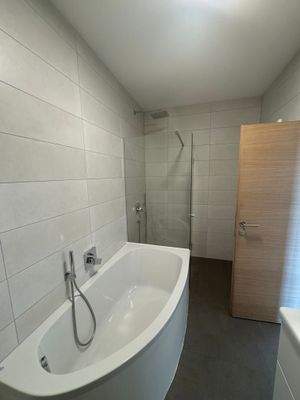 Badezimmer mit Badewanne und Dusche