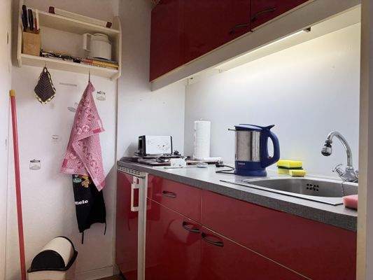 Küche mit 4 Herdplatten, Kühlschrank und Spüle