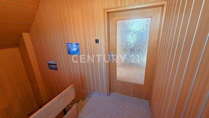 Treppenhaus im Obergeschoss mit Zugang zur Wohnung