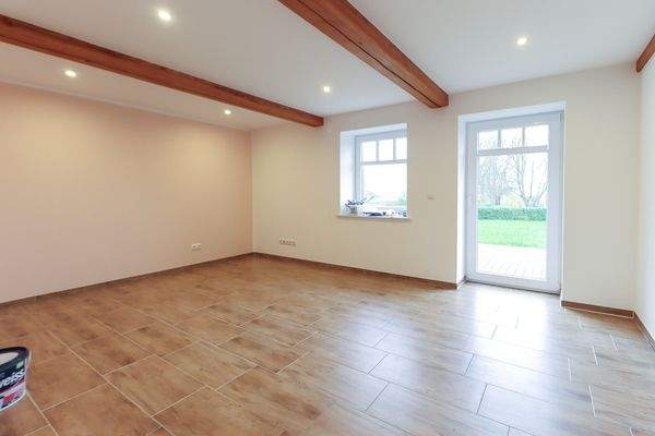 Ein geräumiges Wohnzimmer mit Zugang zur Terrasse und den Garten