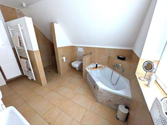 Zu dem gehobenen Komfort gehört eine große, bodenebene Dusche und eine gemütliche Badewanne