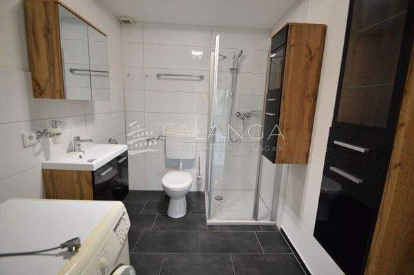 Badezimmer mit Dusche und Waschmaschinenanschluss