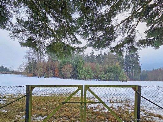 Weitere Grundstücksfläche hinter Gartenzaun