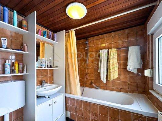 Badezimmer mit Badewanne und Fenster