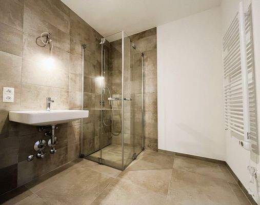 Badezimmer mit WC, Waschbecken, Walk-In-Dusche und Waschmaschinenanschluss