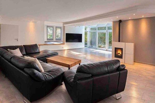 Offener Wohnbereich mit Kamin und großer Fensterfront