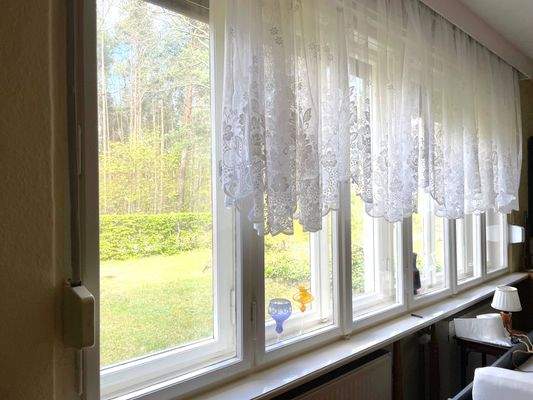 Wohnzimmer m. großer Fensterfront, Blick ins Grüne