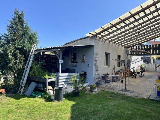 überdachte Freifläche mit Pergola und Nebengebäude
