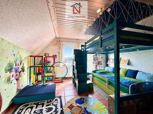 Kinderzimmer mit Hochbett und Spielfläche