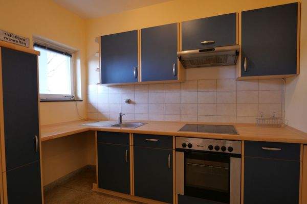 Küche mit Einbauschränken und Geräten