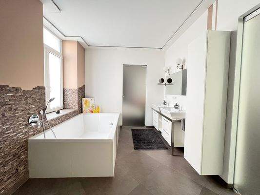 Großzügiges Tageslichtbadezimmer mit großer Badewanne und zwei Waschbecken 