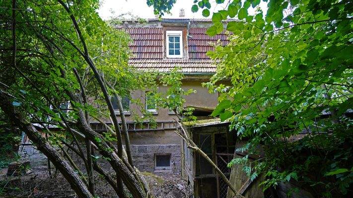 Rückansicht mit baufälligem Schuppen davor