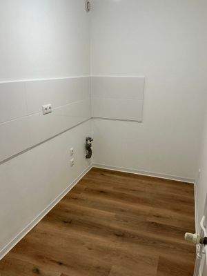 Küche mit Bodenbelag in Holzoptik, Wände weiß angelegt, Fliesenspiegel weiß (neu)