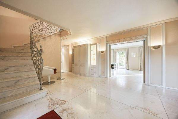 Stilvolles Entrée mit maßgefertigten Einbauschränken und Zugang in den hellen Wohnbereich