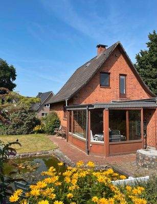 Rückansicht-charmantes Backsteinhaus mit Wintergarten und Teich