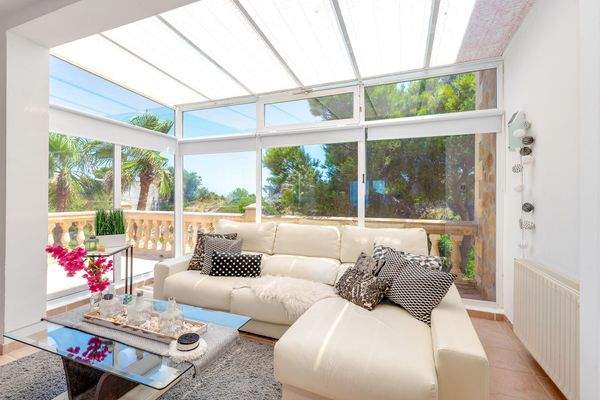 Helles Wohnzimmer mit Kamin und Zugang zur sonnigen Terrasse mit Weitblick