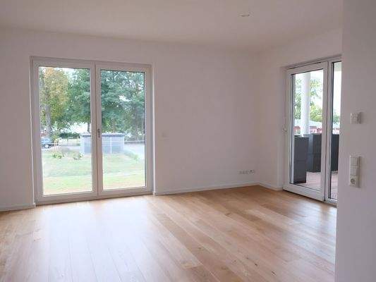 Wohnzimmer mit Zugang zum überdachten Balkon