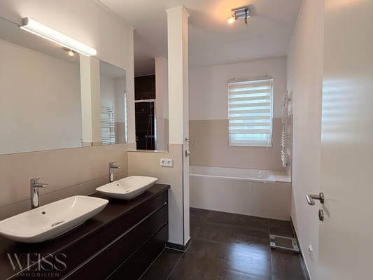 Tageslichtbad mit Badewanne & bodentiefer Dusche angrenzend zum Hauptschlafzimmer