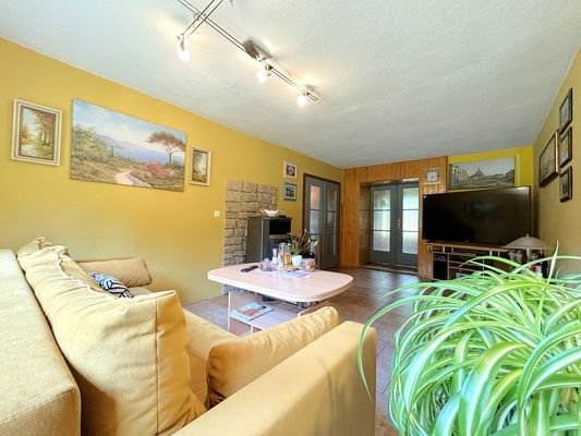 gemütliches Wohnzimmer mit Kamin und Blick in den Garten