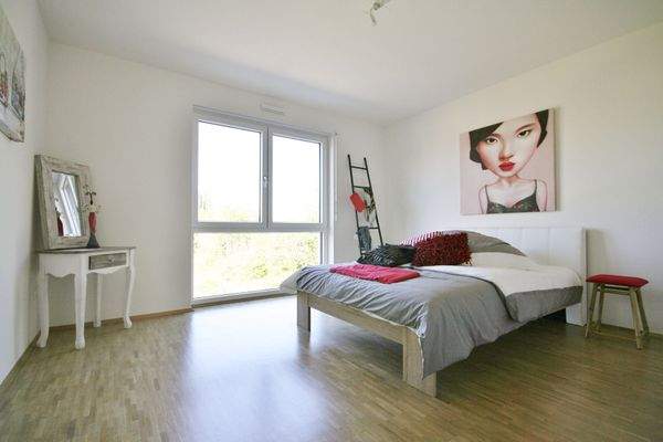 Schlafzimmer mit Parkett und bodentiefen Fenstern (Musterwohnung).JPG