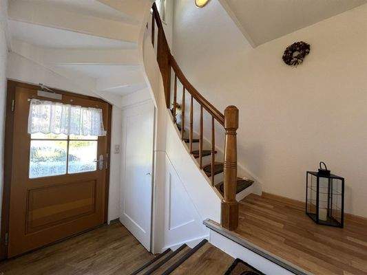 Helles, freundliches Treppenhaus mit Holztreppe