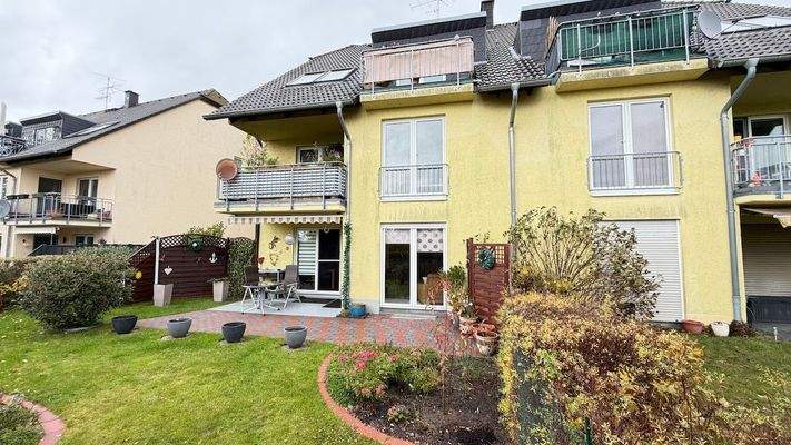 Hausansicht mit Mietergärten und Balkonen