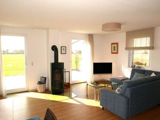 Lichtdurchfluteter Wohnbereich mit Kaminaofen