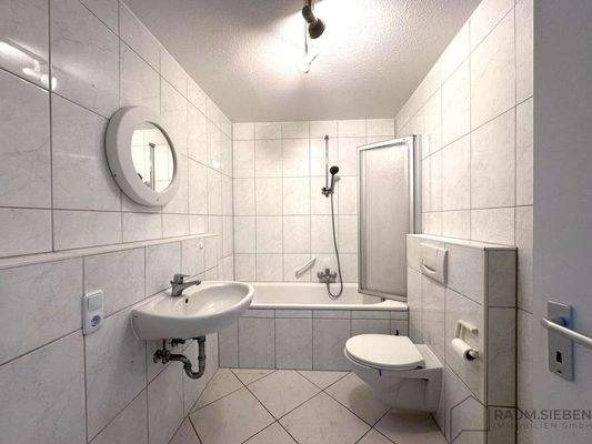 Badezimmer mit Badewanne und Waschmaschinenanschluss